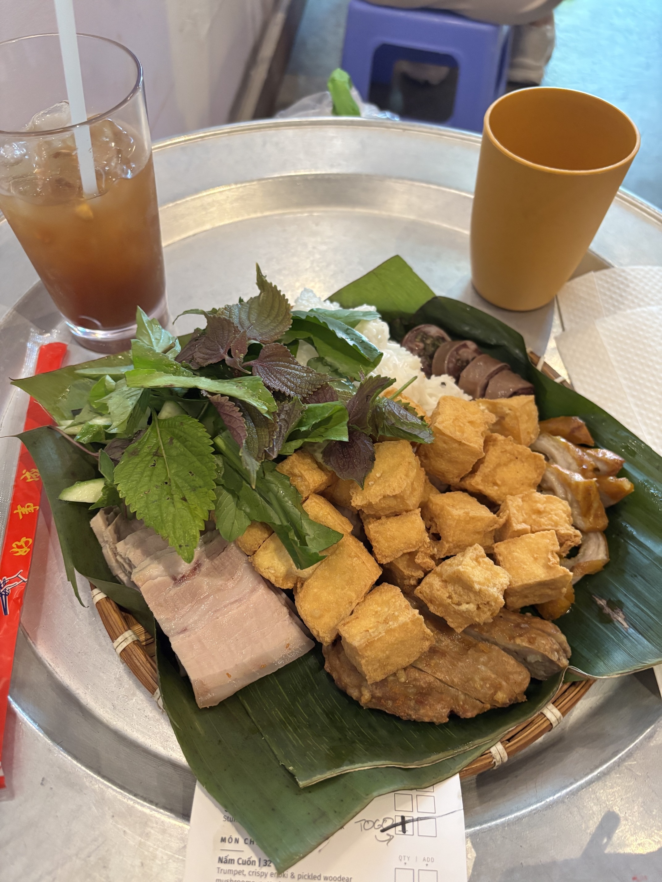 Plate of Bún Đậu Mắm Tôm over banana leaf and bamboo steamer.